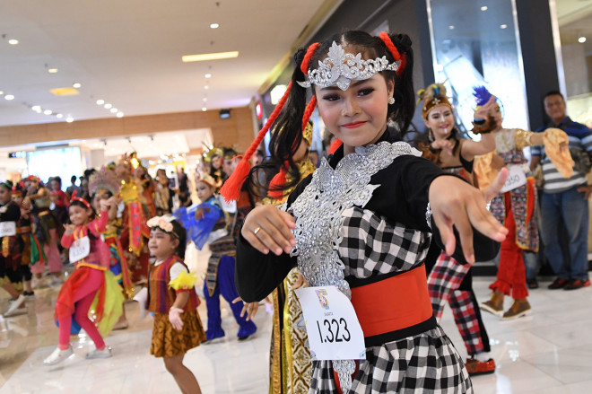 Penari berkostum tradisional Indonesia menari dalam perhelatan 