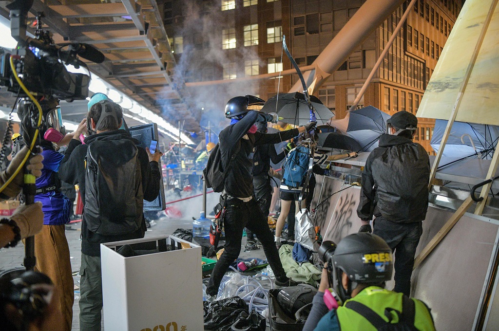 Demonstran Hong Kong bersiap menembakkan arah panah dalam ketegangan di area PolyU, Senin 18 November 2019. (Foto: AFP/ANTHONY WALLACE)