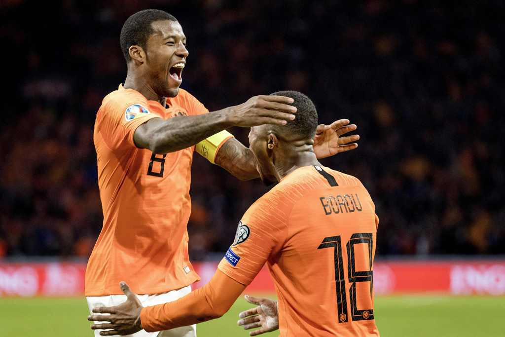 Gelandang Belanda, Georginio Wijnaldum, merayakan golnya bersama Myron Boadu (AFP/Koen van Weel)