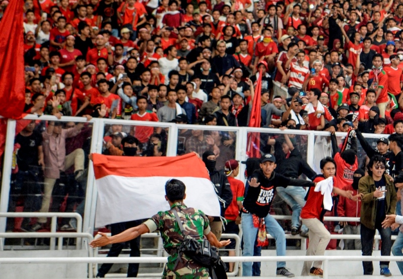 Sejumlah suporter melompati pagar pembatas saat pertandingan Timnas Indonesia melawan Timnas Malaysia pada laga perdana Grup G Kualifikasi Piala Dunia 2022 zona Asia di Stadion Utama Gelora Bung Karno. (ANTARA FOTO/Hafidz Mubarak A)