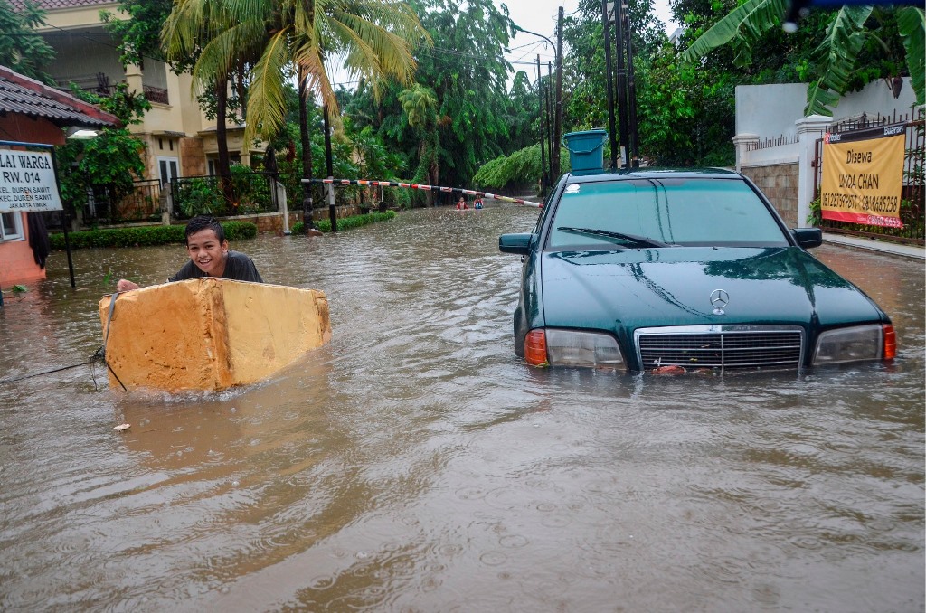 Sejumlah anak bermain saat banjir di Duren Sawit, Jakarta Timur, Rabu (1/1/2020). Foto: Antara/Fakhri Hermansyah