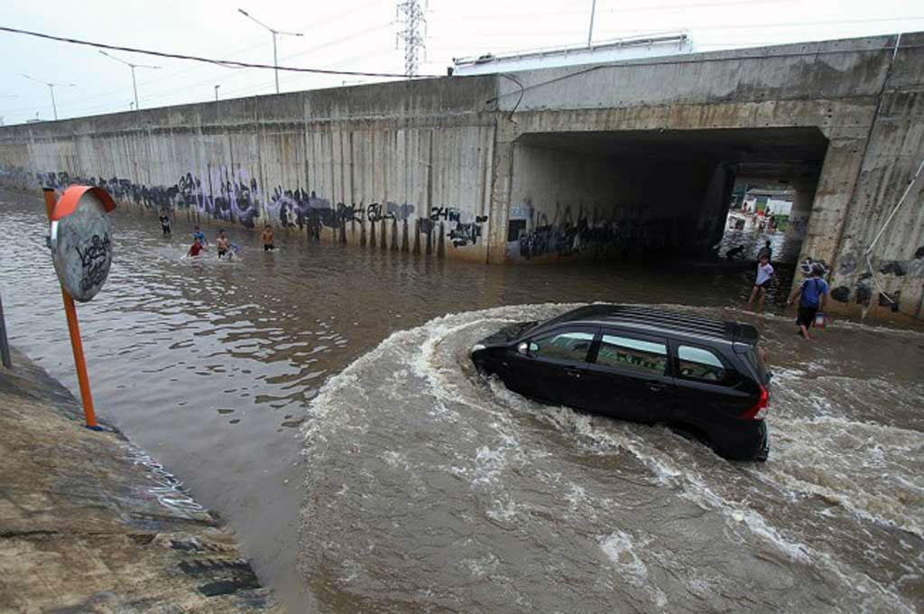 Jangan melintas genangan air dengan kecepatan tinggi. Antara Foto 