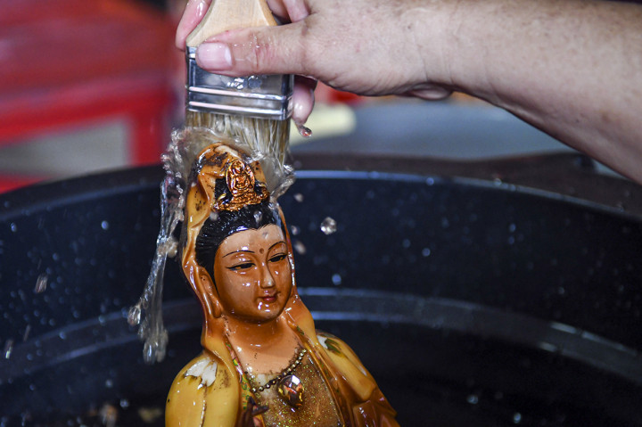 Bersih-bersih Patung Dewa Jelang Perayaan Imlek