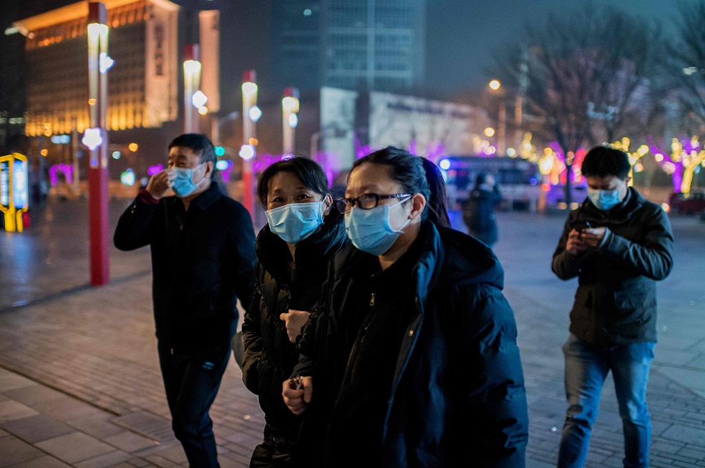 Warga mengenakan masker saat berjalan di kota Wuhan, Tiongkok, 28 Januari 2020. (Foto: AFP/NICOLAS ASFOUR)