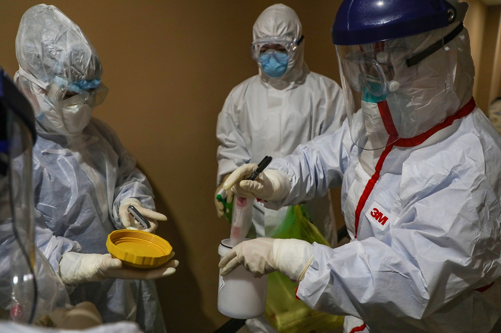 Staf medis mengambel sampel yang diambil dari pasien virus korona COVID-19 di Wuhan, Tiongkok, 4 Februari 2020. (Foto: AFP/STR)