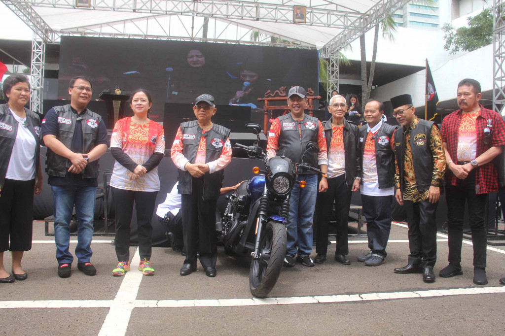 Ma'ruf Amin menggunakan baju kebesaran serta rompi bikers Motor Besar Indonesia (MBI). MBI