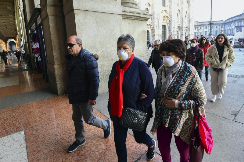 Wisatawan di Italia gunakan masker untuk cegah virus korona. Foto: AFP