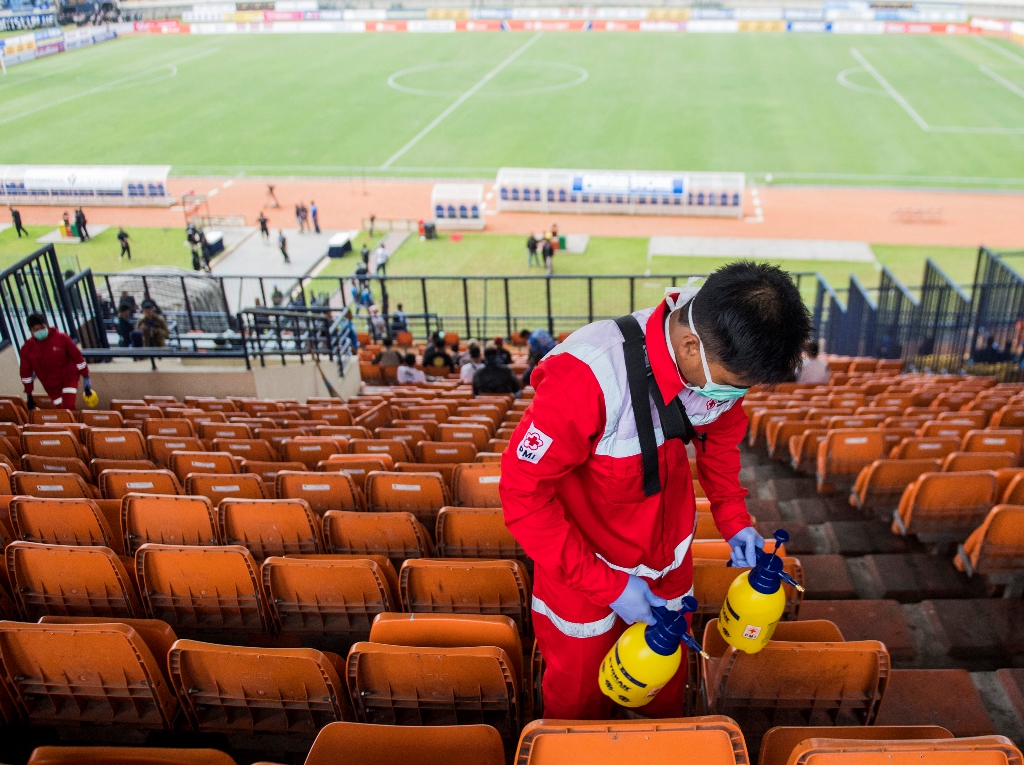Petugas PMI menyemprotkan cairan disinfektan di bangku penonton sebelum laga Persib Bandung melawan PSS Sleman di stadion Si Jalak Harupat. (ANTARA FOTO/M Agung Rajasa)