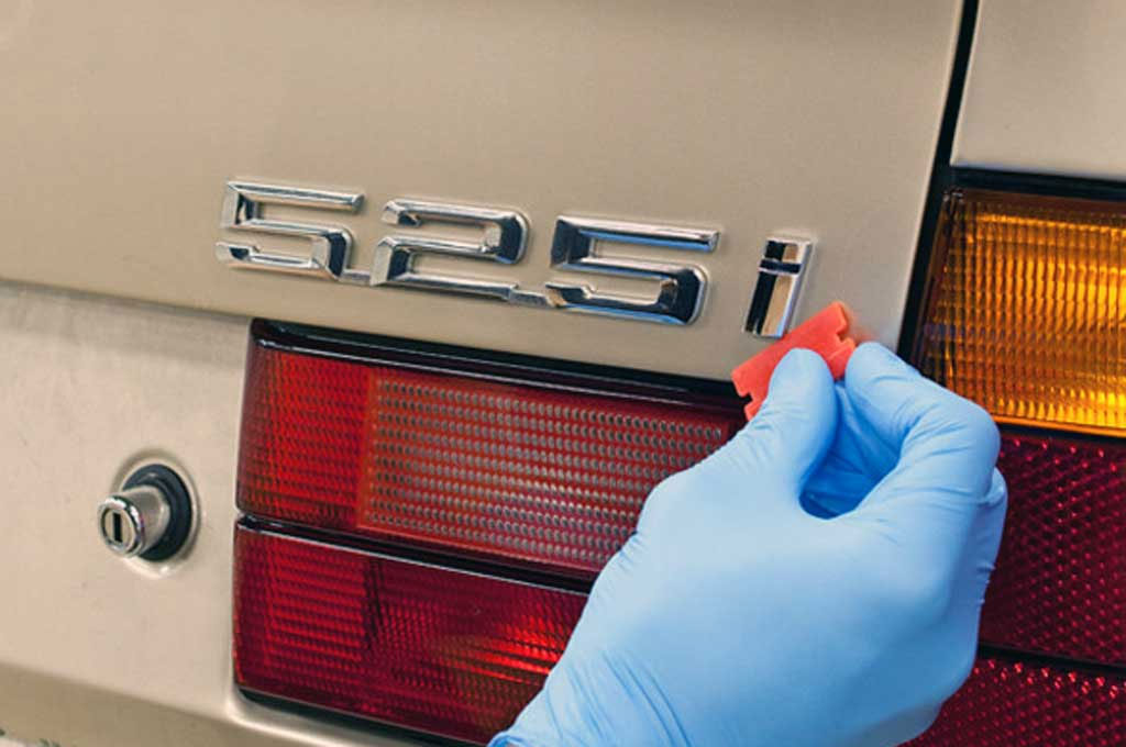 Bersihkan emblem mobil agar tetap terlihat baru dan terawat. Detailimage