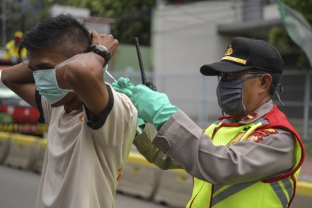 Polisi memberikan masker kepada pengendara sepeda motor saat penerapan PSBB di kawasan Menteng, Jakarta, Sabtu, 11 April 2020. Foto: Antara/Nova Wahyudi