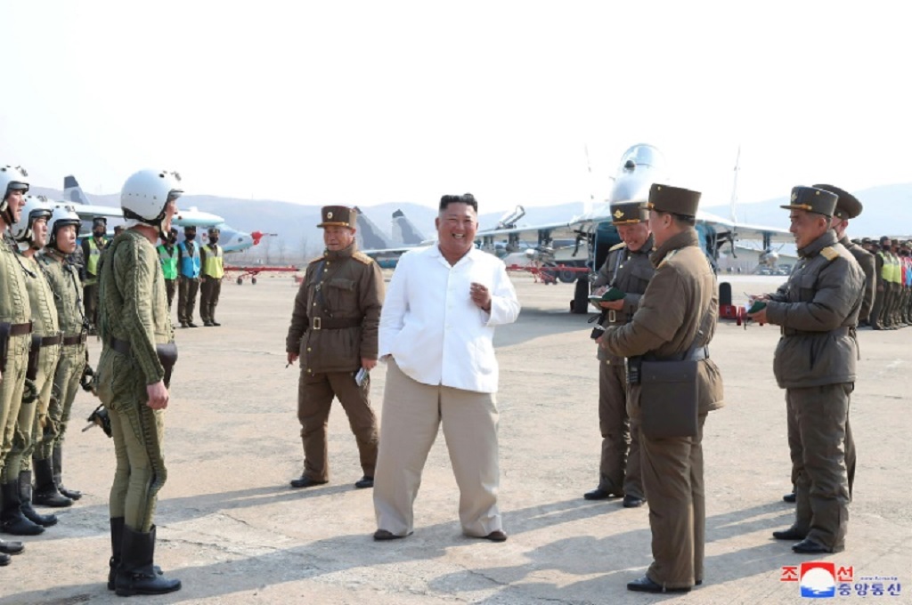 Foto tertanggal 12 April 2020 memperlihatkan Kim Jong-un yang sedang memantau deretan pesawat militer Korut. (Foto: KCNA VIA KNS/AFP/STR