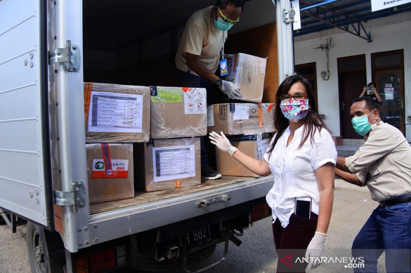 Anggota Gugus Tugas Percepatan Penanganan Covid-19 Nusa Tenggara Timur mengecek bantuan reagen untuk pemeriksaan covid-19 di Bandara Udara El Tari Kupang. (Foto: ANTARA/Benny Jahang)	