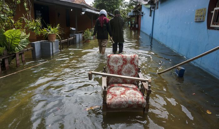 Sejumlah warga melintas di jalan yang tergenang banjir rob di Slamaran, Pekalongan, Jawa Tengah, Rabu (3/6/2020)  