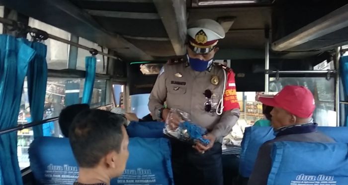 Anggota Polres Tasikmalaya Kota memberikan masker kepada penumpang tidak memakai masker di Terminal Indihiang, Kota Tasikalmalaya. (Foto: MI/Kristiadi)