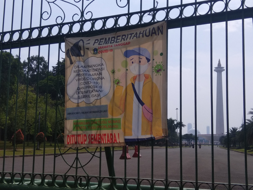 Spanduk pemberitahuan Monumen Nasional (Monas), Jakarta Pusat, yang masih ditutup di fase PSBB transisi. Medcom.id/Fachri Audhia Hafiez