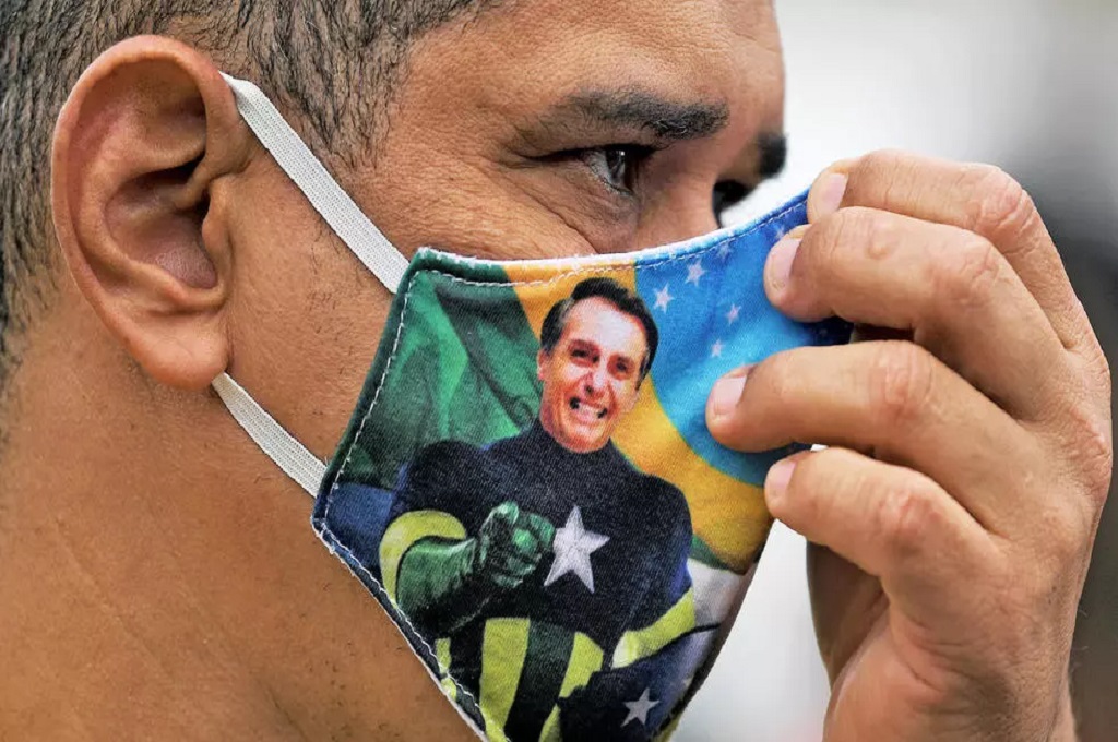Seorang warga Brasil menggunakan masker bergambar foto Presiden Jair Bolsonaro. (Foto: CARL DE SOUZA AFP/File)