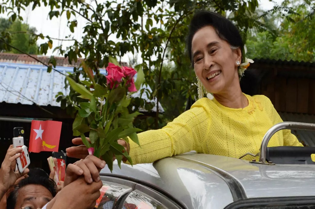 Pemimpin de facto Myanmar Aung San Suu Kyi menerima bunga dari para pendukungnya. (Foto: Romeo Gacad/AFP)