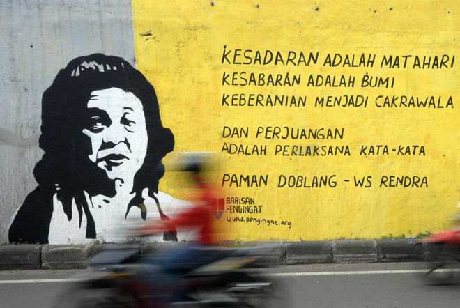 Sejumlah pengendara motor melintas di dekat dinding mural beri si syair puisi W.S Rendra di Jalan TB Simatupang. (Foto: MI/Bary Fathahilah)