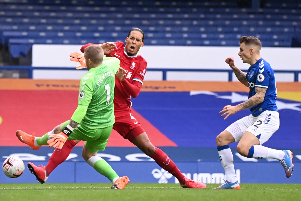 Jordan Pickford saat menghalau Virgil van Dijk. (Foto: AFP/Peter Byrne)