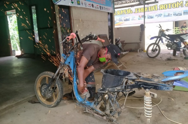 Khosikin merangkai sepeda motor roda tiga untuk difabel