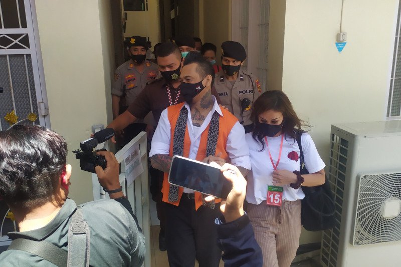 Terdakwa Jrx, didampingi istrinya setelah mengikuti persidangan di Pengadilan Negeri Denpasar, Selasa (27/10/2020). (Antara/Ayu Khania Pranisitha/2020)