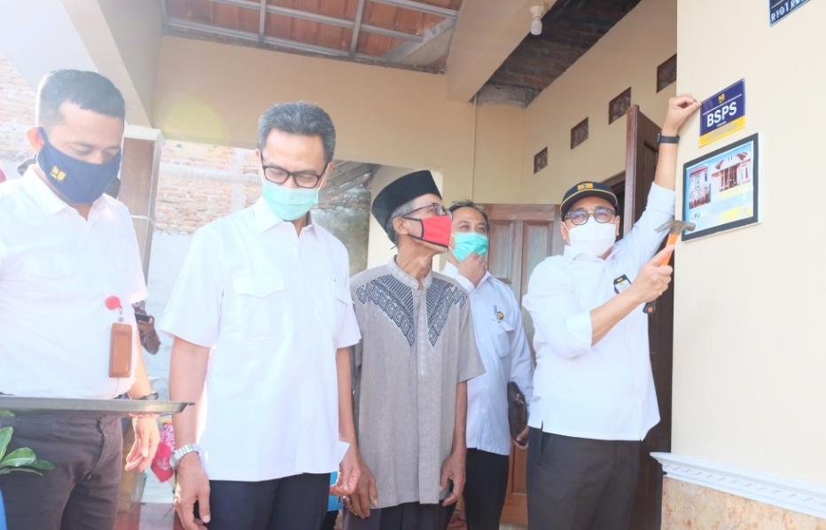 Dirjen Perumahan Kementerian PUPR Khalawi Abdul Hamid memasang pancang pada rumah yang telah diperbaiki. Foto: Kementerian PUPR
