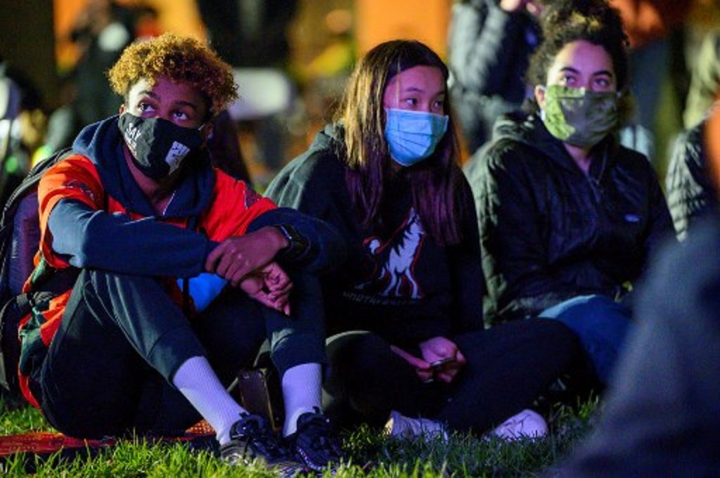 Sekelompok pemuda AS pendukung Joe Biden menyaksikan hasil penghitungan pilpres melalui sebuah layar di Washington pada Selasa malam, 3 November 2020. (Eric BARADAT/AFP)