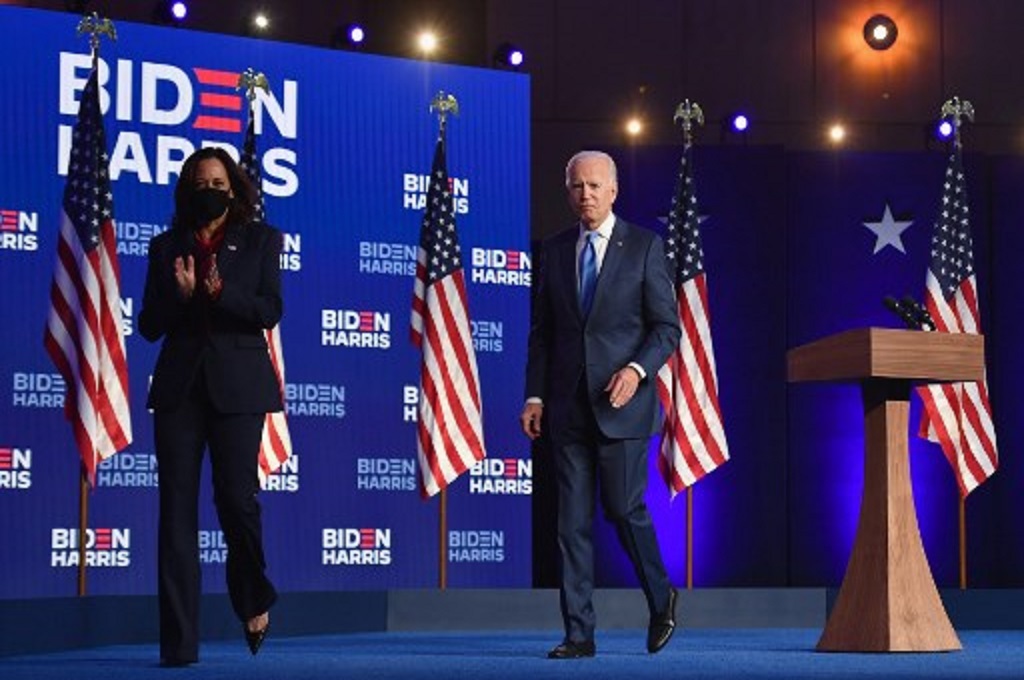 Joe Biden (tengah) dan Kamala Harris meninggalkan panggung pidato di Wilmington, Delaware, AS pada Jumat malam, 6 November 2020. (Angela Weiss/AFP)
