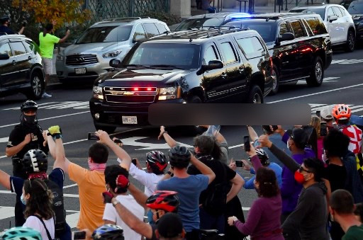 Warga menunjukkan gestur kasar ke arah iring-iringan Presiden AS Donald Trump. Foto: AFP