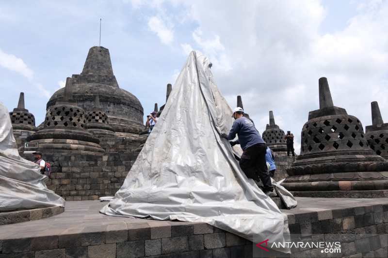 Petugas Balai Konservasi Borobudur menutup stupa candi dengan terpal paulin untuk mengntisipasi erupsi Gunung Merapi. (ANTARA/Anis Efizudin)
