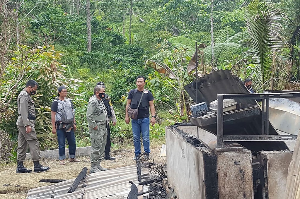 Polisi dan warga berada di lokasi aksi terorisme di Desa Lembantongoa, Kabupaten Sigi, Sulteng. (AFP/Kepolisian Sulteng)