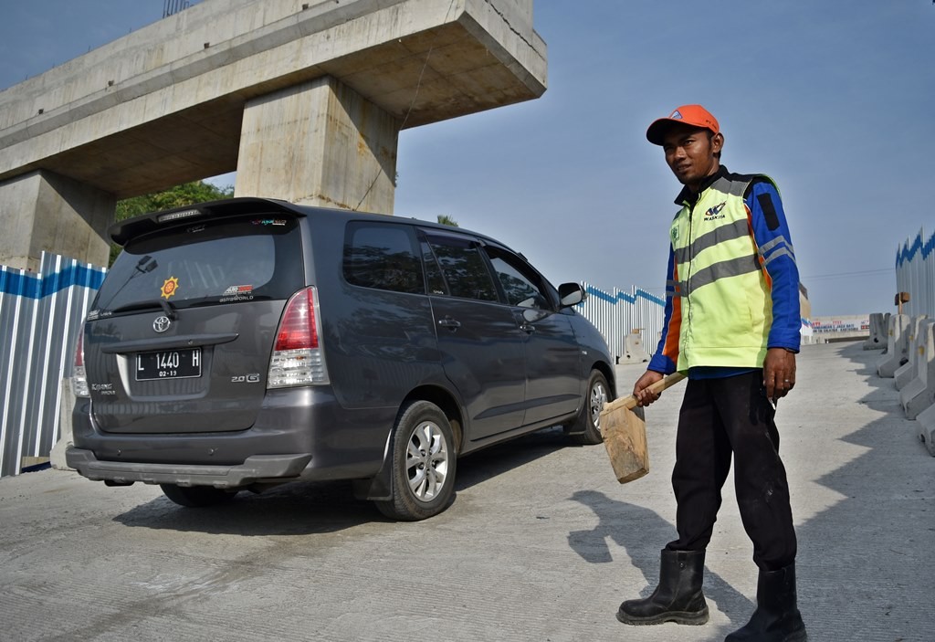 Petugas pengganjal ban bersiaga saat mobil pemudik tidak kuat melaju di tanjakan Jembatan Kali Kenteng. ANT/ADITYA PRADANA PUTRA