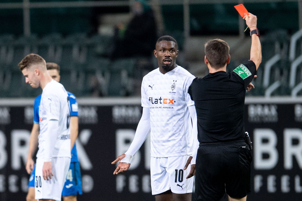 Penyerang Borussia Monchengladbach, Marcus Thuram, mendapat kartu merah usai meludahi lawan (AFP/Marius Becker)