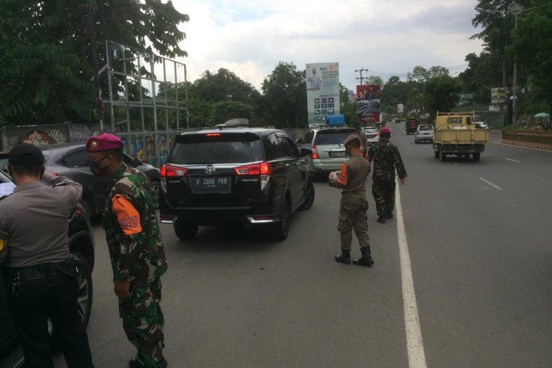  Satgas Covid-19 Kota Bandarlampung memberhentikan kendaraan dari luar daerah di posko perbatasan Rajabasa. Senin. (28/12/2020). (ANTARA/Dian Hadiyatna)
