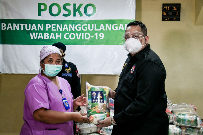 Ketua Dewan Pimpinan Wilayah DKI Jakarta, Garda Pemuda Nasdem Nova Harivan Paloh (kanan) secara simbolis memberikan bantuan pada Kepala Sekretariat dan Rumah Tangga RS St Carolus Dr. Florentina Setiati (kiri) di Jakarta.
