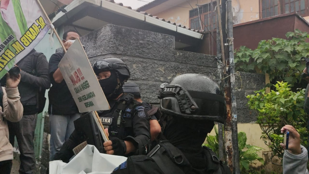 Polisi tengah menurunkan atribut FPI. Medcom.id/Christian