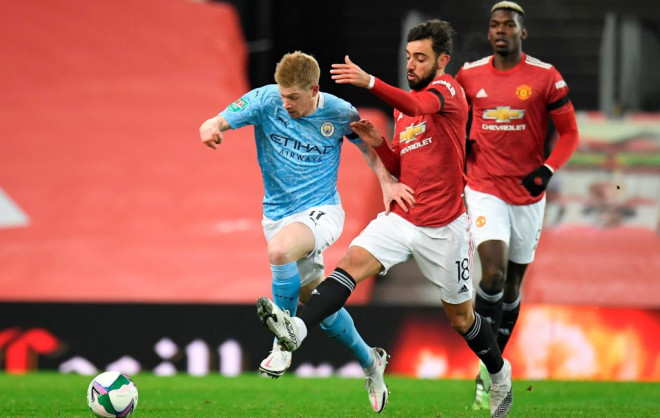 Gelandang Manchester United Bruno Fernandes (kiri) saat berduel dengan gelandang Manchester City Kevin de Bruyne (kanan) (Foto: AFP/Peter Powell)