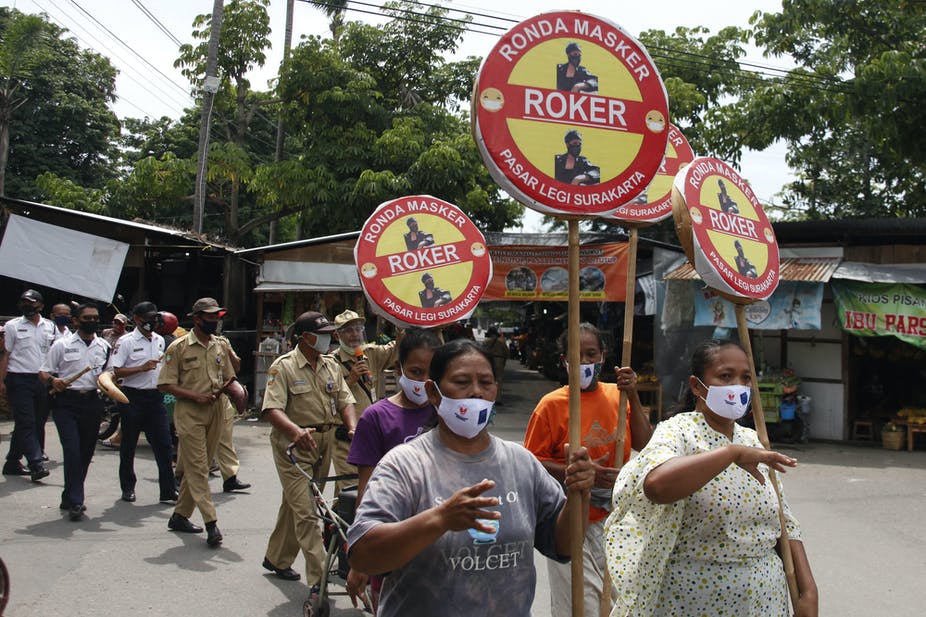 Relawan petugas Dinas Kesehatan dan Dinas Perdagangan berkampanye pentingnya pakai masker untuk cegah COVID-19 di Pasar Legi, Solo, 4 Januari 2021. ANTARA FOTO/Maulana Surya/hp