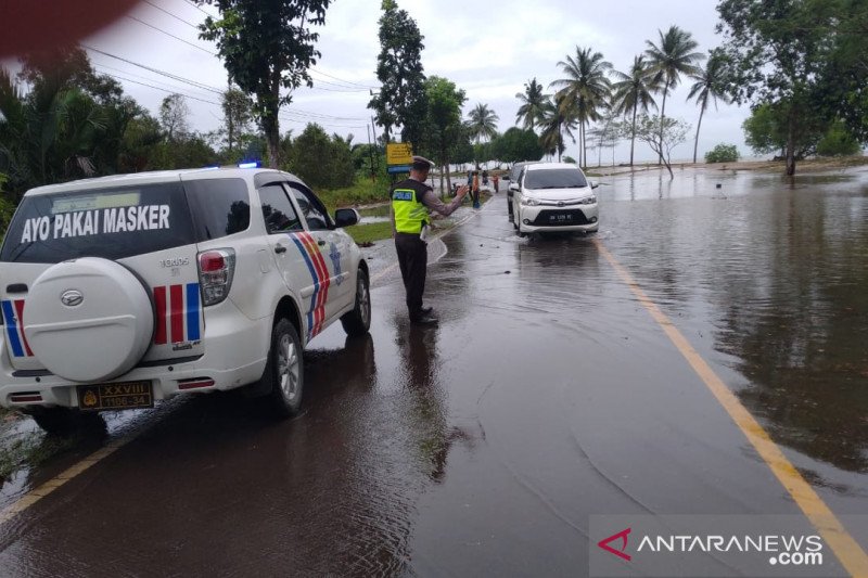  Petugas kepolisian mengatur arus lalu lintas di lokasi banjir rob  kawasan pesisir Pantai Arung Dalam, Bangka Tengah, Babel, Rabu, 13 Januari 2021. ANTARA/Ahmadi