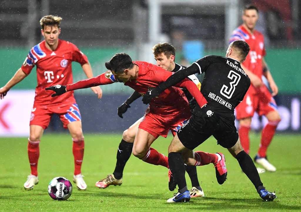 Penyerang Bayern Muenchen, Robert Lewandowski, mencoba melepaskan diri dari kawalan pemain Holsten Kiel (twitter: @FCBayern)