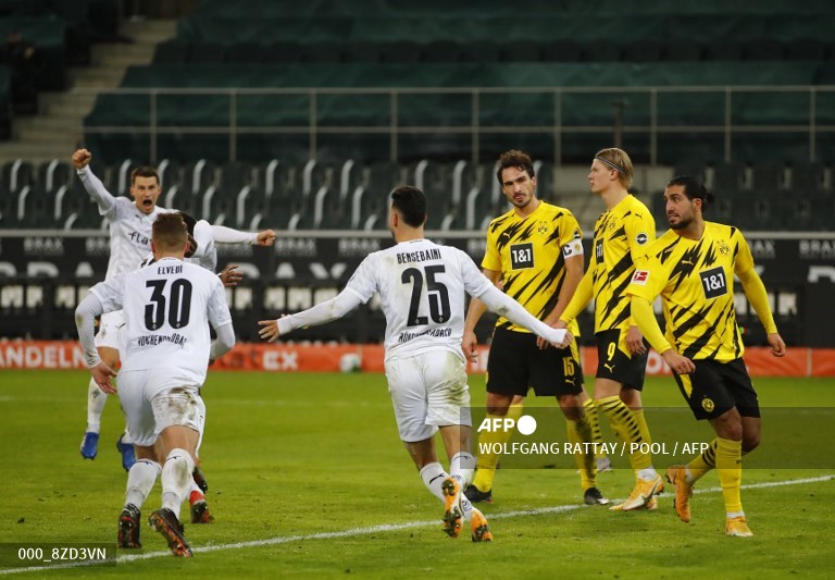 Para pemain Borussia M'Gladbach merayakan gol di depan pemain Borussia Dortmund. (WOLFGANG RATTAY / POOL / AFP)