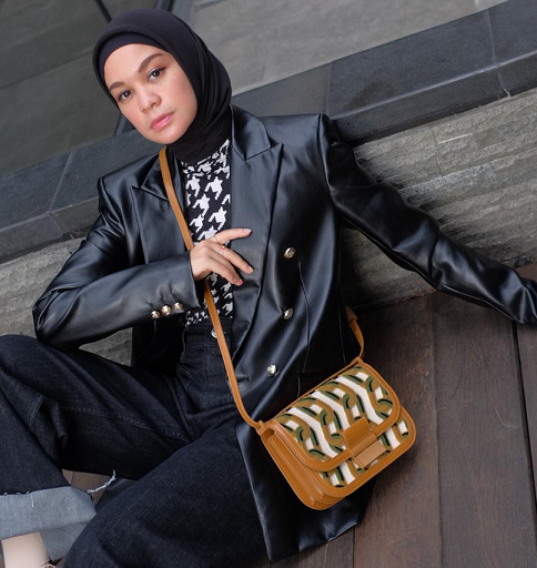 Tas kulit dengan motif retro geometris tampil outstanding dalam padupadan ini. (Foto: Dok. Charles&keith)