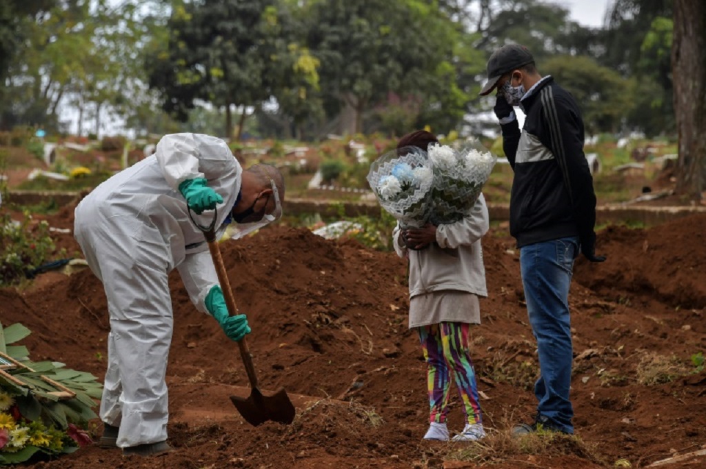 Petugas menguburkan jenazah pasien covid-19 di Brasil. (AFP)