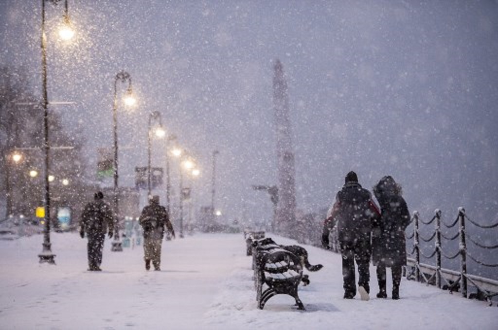 Warga berjalan di tengah guyuran salju di Boston, AS pada Senin, 1 Februari 2021. (Joseph Prezioso/AFP)