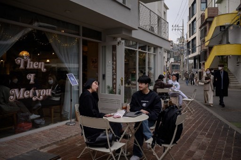 Warga bersantai di sebuah kafe di Seoul, Korea Selatan pada Minggu, 14 Februari 2021. (Ed JONES/AFP)