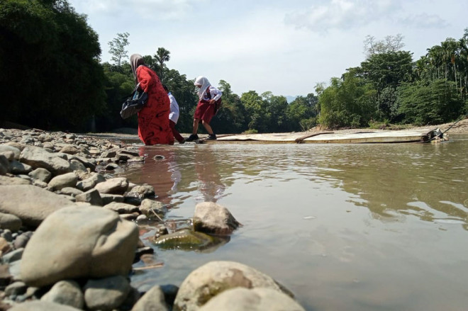Anak-anak murid SD Siron menyeberangi Sungai Murtala di  Desa Siron Blang, Kecamatan Kuta Cot Glie, Kabupaten Aceh Besar, Aceh, dengan menaiki rakit buatan, Rabu, 17 Februari 2021.