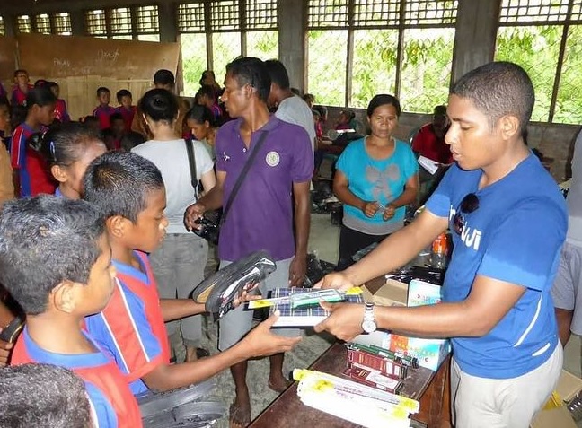 Relawan memberikan sepatu dan alat tulis. (Foto: Shoes for Flores)