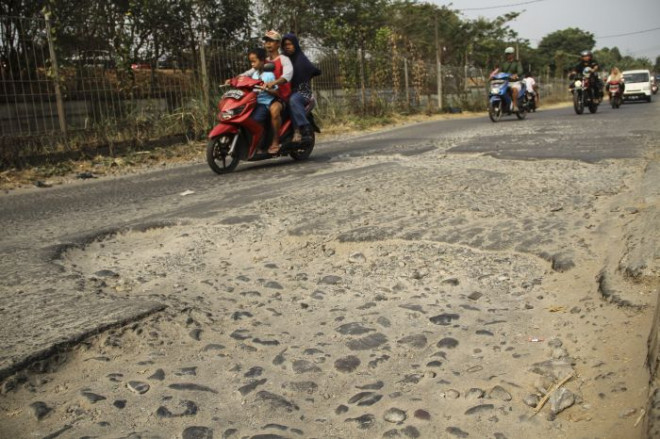 ANTARA FOTO/Asprilla Dwi Adha. Sejumlah pengendara menghindari jalan yang rusak di Jalan Gas Alam, Depok, Jawa Barat, Minggu (25/8/2019)