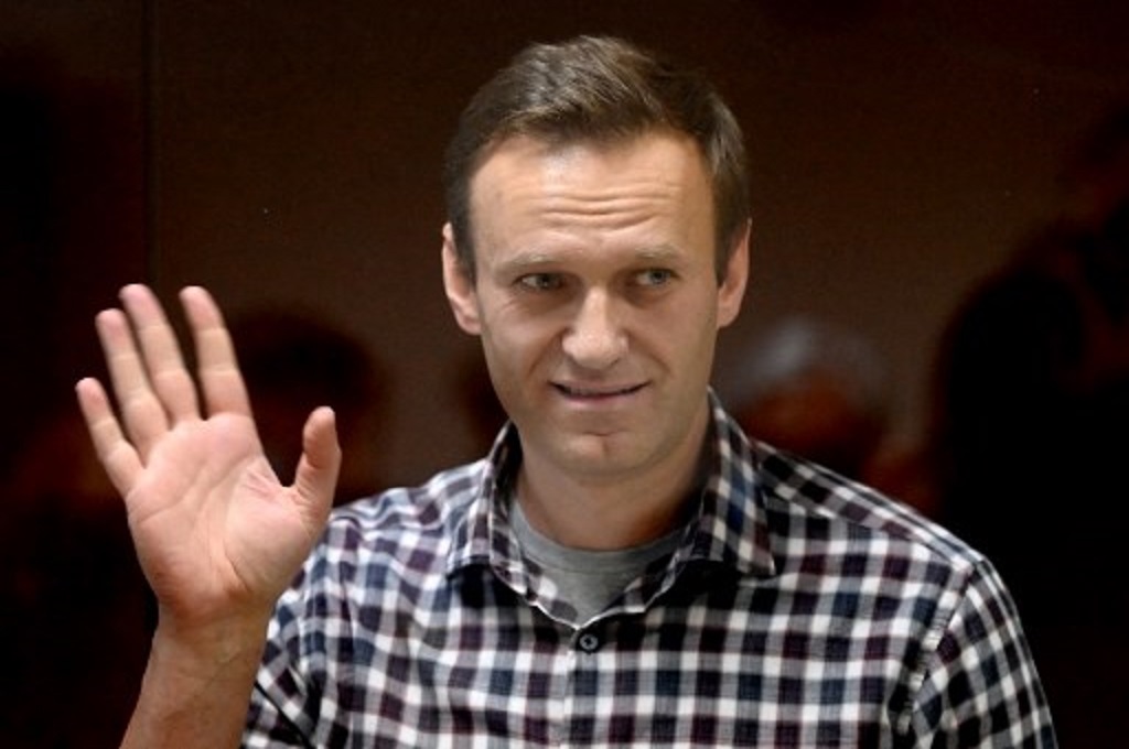 Pemimpin oposisi Rusia Alexei Navalny melambaikan tangan di sebuah gedung pengadilan di Moskow pada 20 Februari 2021. (Kirill KUDRYAVTSEV/AFP)