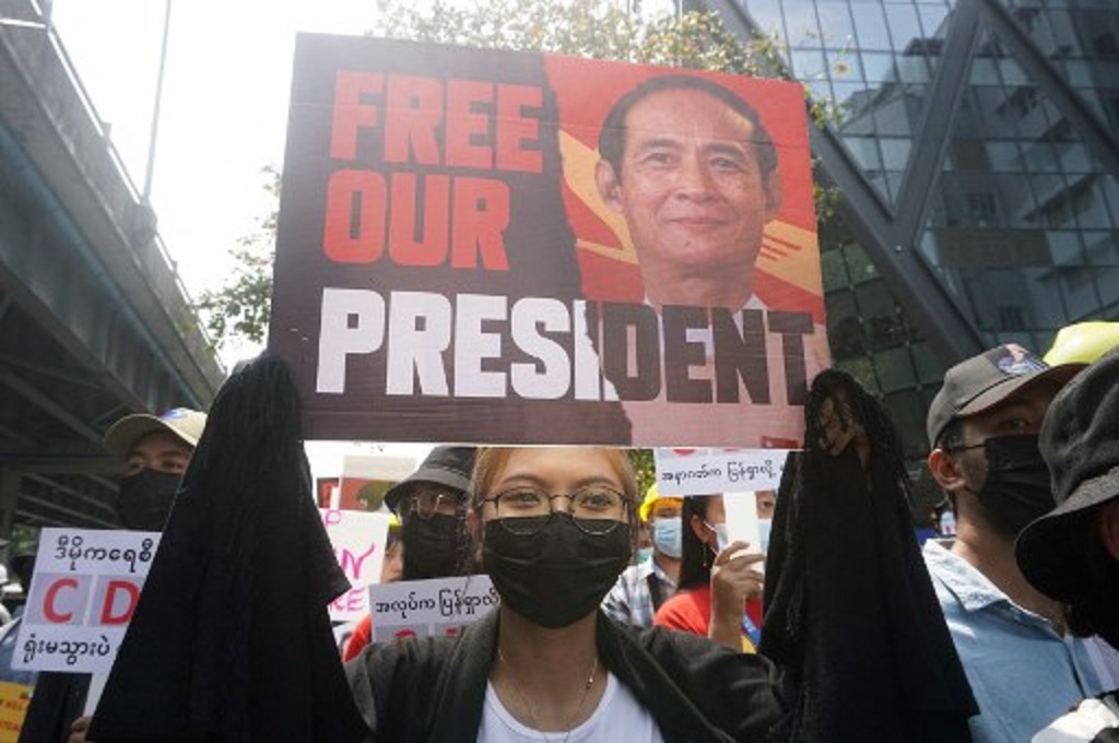 Demonstran membawa poster wajah Presiden Myanmar Win Myint dalam unjuk rasa di kota Yangon pada 21 Februari 2021. (Sai Aung Main/AFP)
